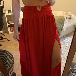 Red flowy skirt with mid leg slit and metal ring detailing at waist. Size sm/m